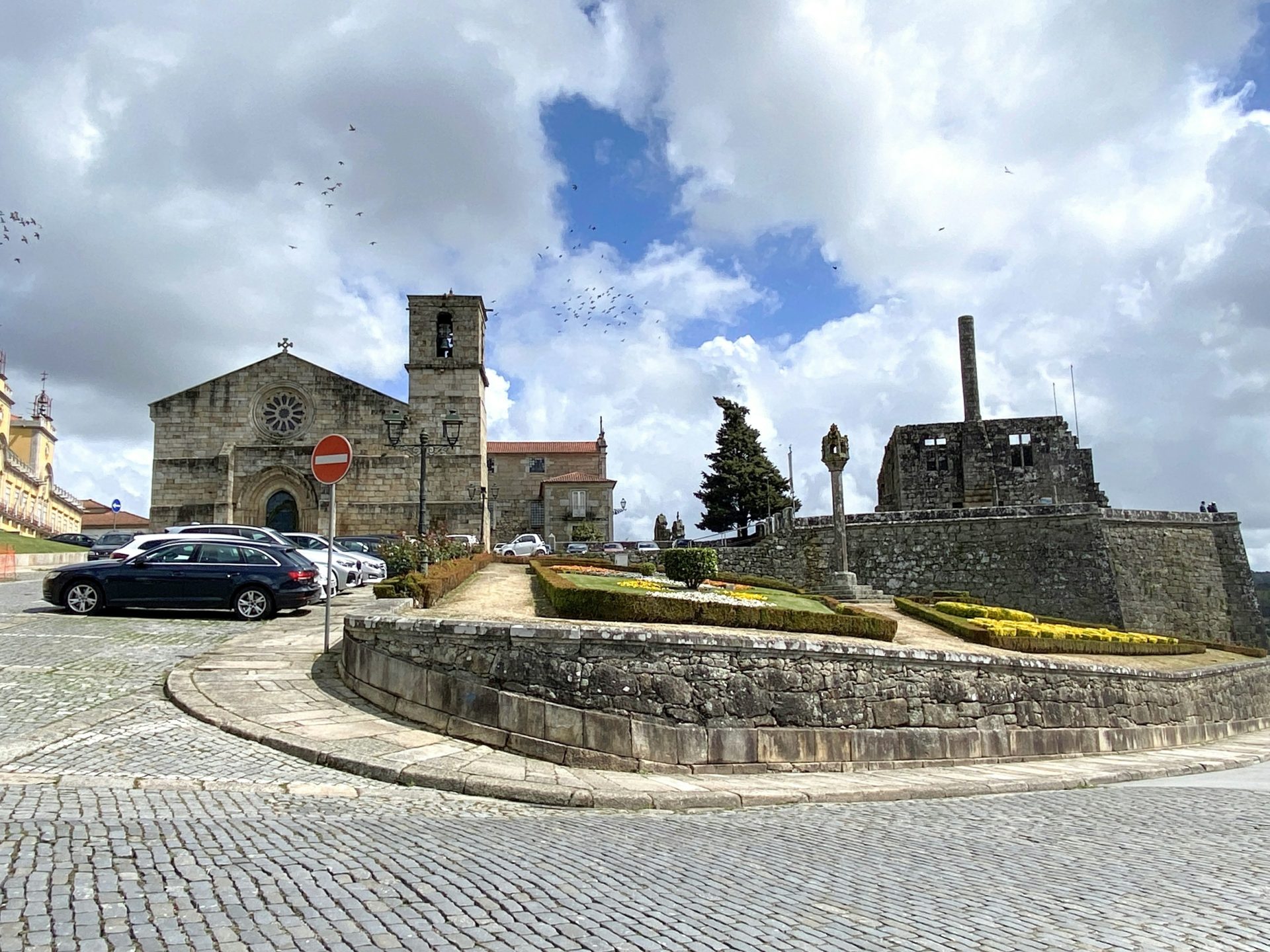 a stone wall with a stone wall and a brick wall with a car parked in front of it